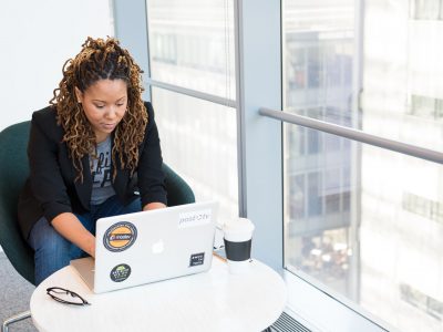 Photo by Christina @ wocintechchat.com woman sits on padded chair while using MacBook during daytime